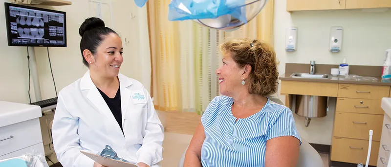 A dental provider talks with a patient